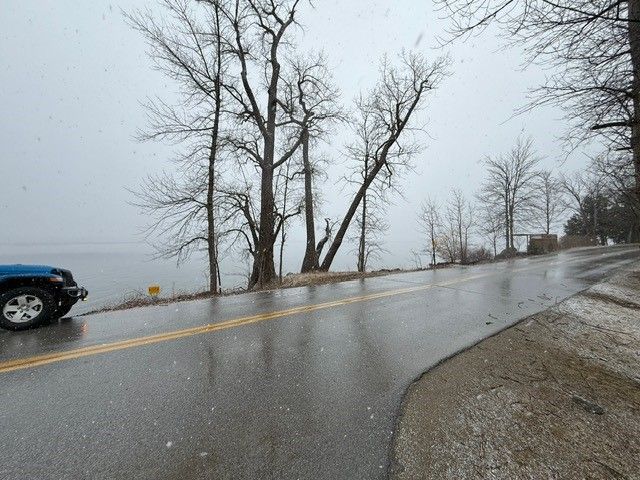 Roadside view of lake on a cloudy day.