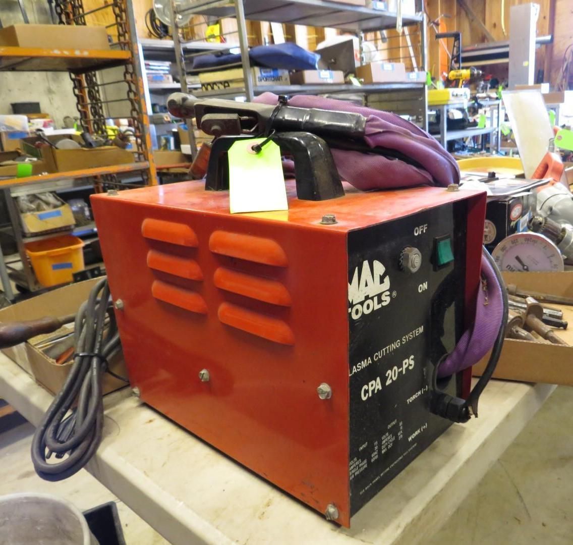 Red and black MAC Tools CPA 20-PS welder on a table with other tools in a shop.