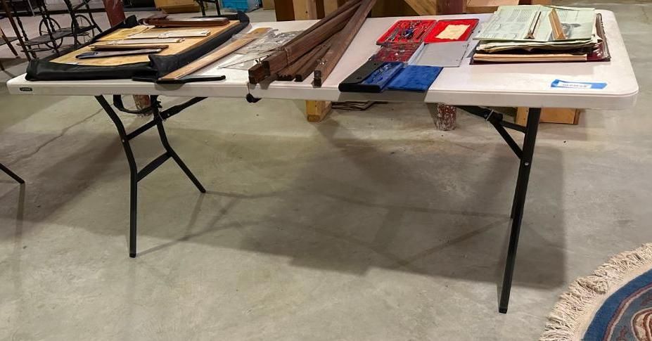 White folding table with various items laid out on top.