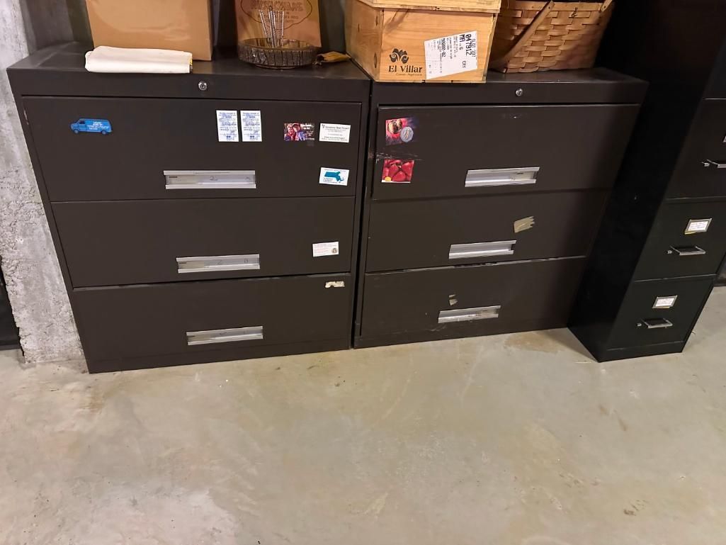 Two brown metal file cabinets with drawers, topped with boxes, in a room with a light-colored floor.