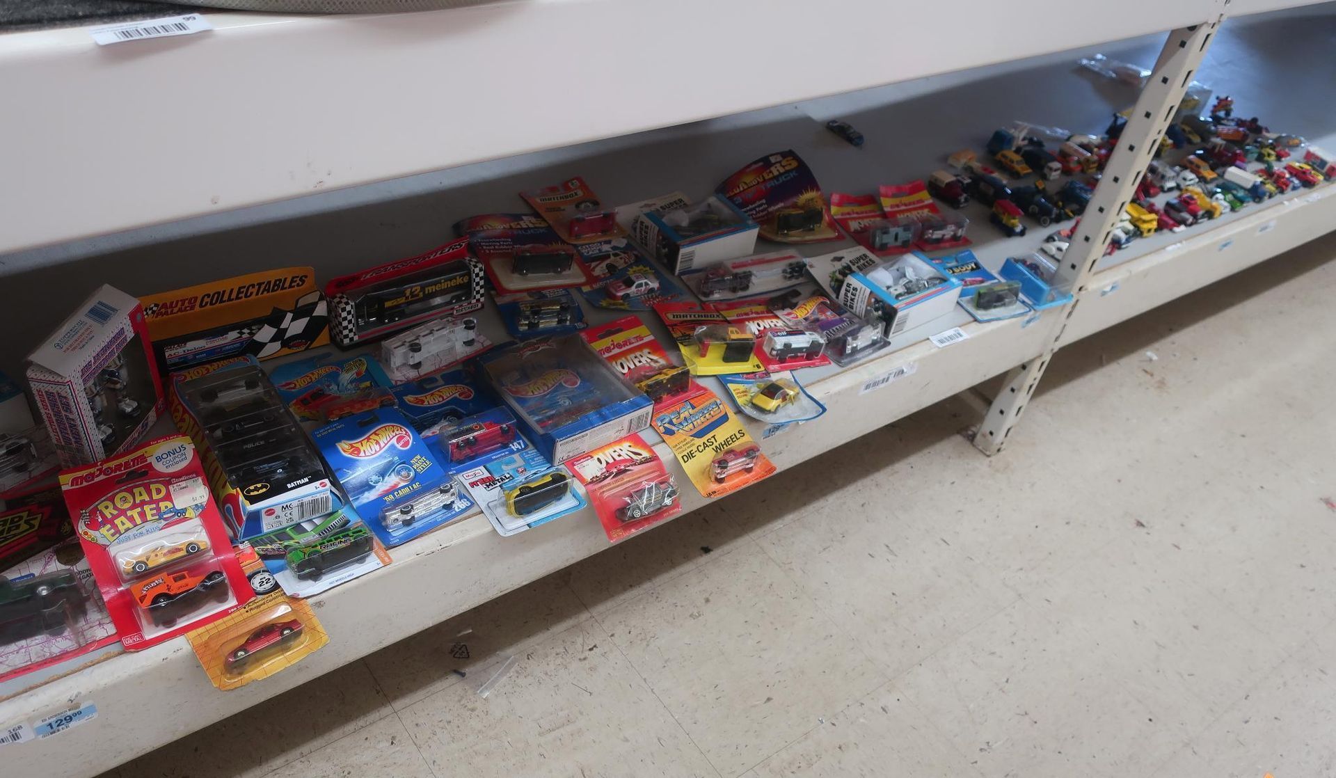 Shelf displaying assorted toy cars and racing game boxes.