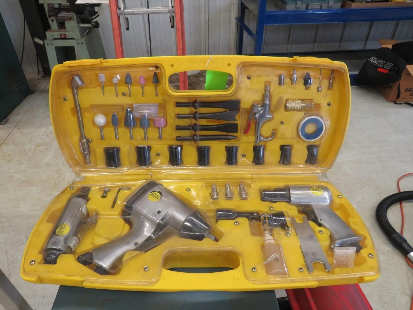 Yellow toolbox open, filled with air tools and bits.