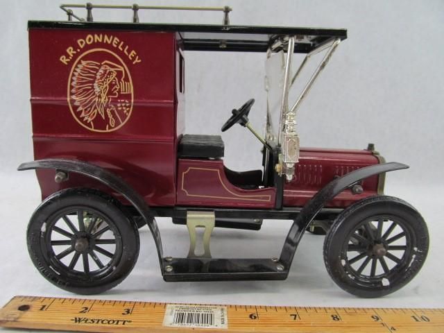 Toy R.R. Donnelley delivery truck in maroon with gold logo and black wheels, with ruler.