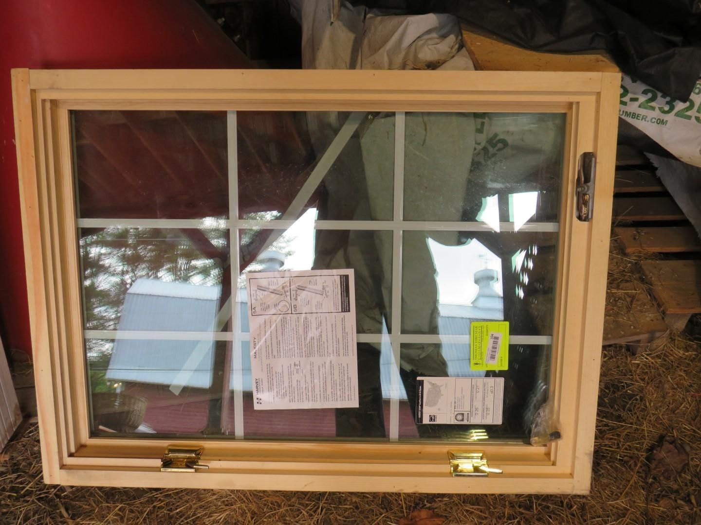 Wooden-framed window with six panes. Several papers and a yellow tag are visible inside the glass.