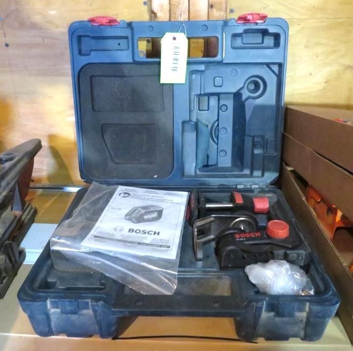 Open blue tool case with Bosch laser level, manual, and accessories.