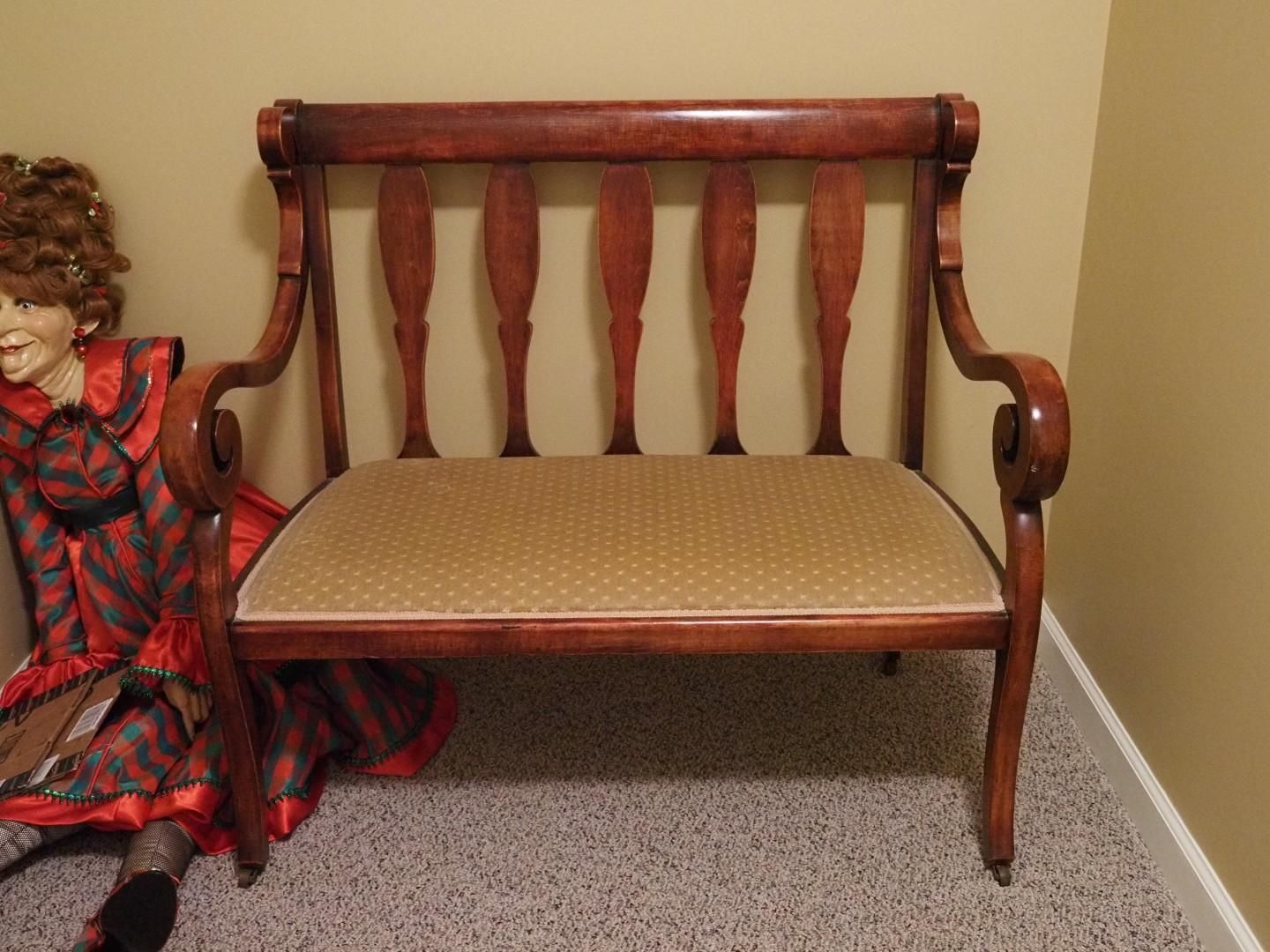 Wooden bench with upholstered seat.