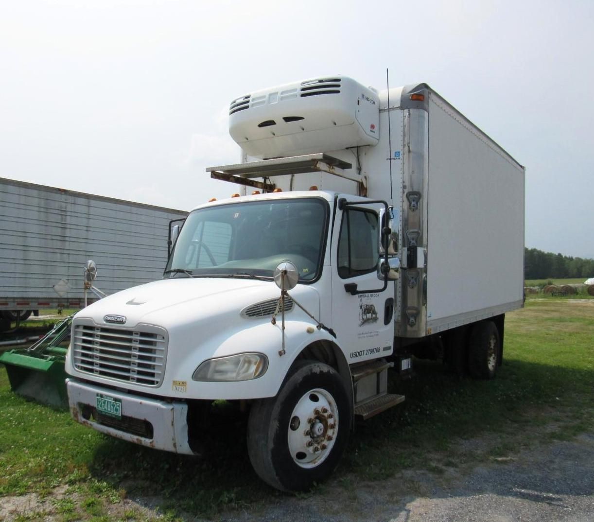 White refrigerated box truck parked outdoors.