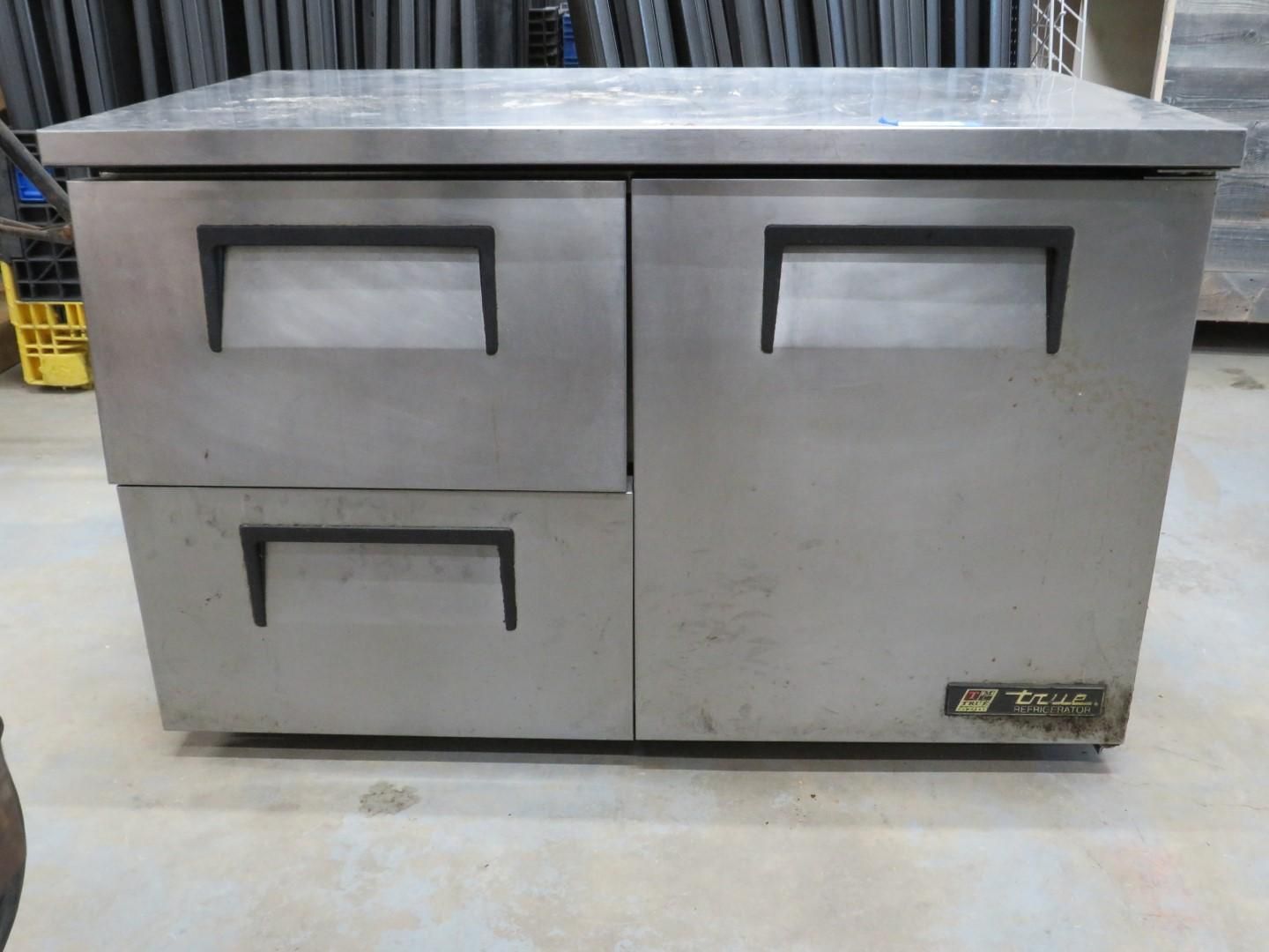 Stainless steel commercial refrigerator with two drawers and one door.