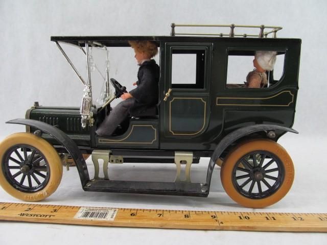 Toy car with driver and passenger. Dark green with tan wheels.