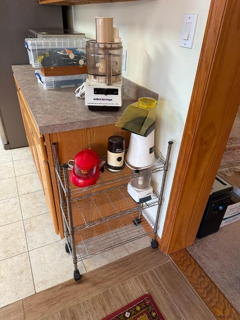Kitchen countertop with appliances: food processor, popcorn maker, coffee maker, and rolling metal shelf.