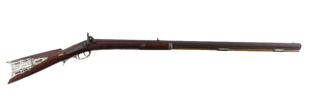 Antique rifle, wooden stock, ornate metal trigger guard, long barrel.