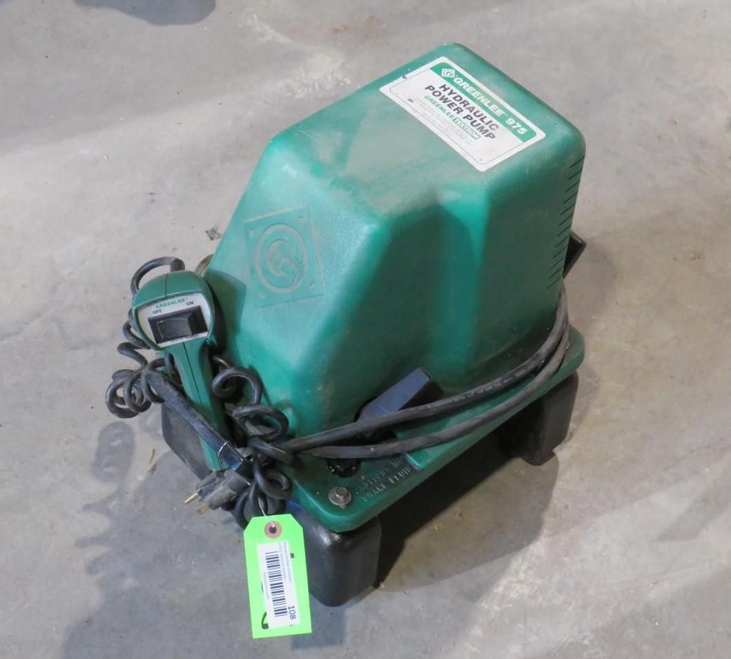 Green septic air pump on a concrete surface with electrical cord and control.