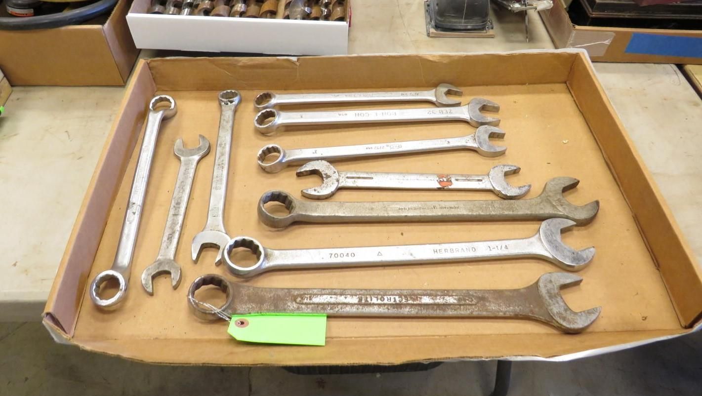Wrenches of various sizes in a cardboard box on a table.
