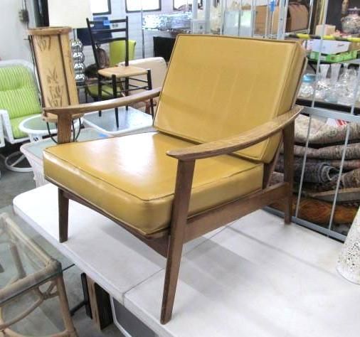 Yellow-cushioned mid-century armchair with wooden frame.