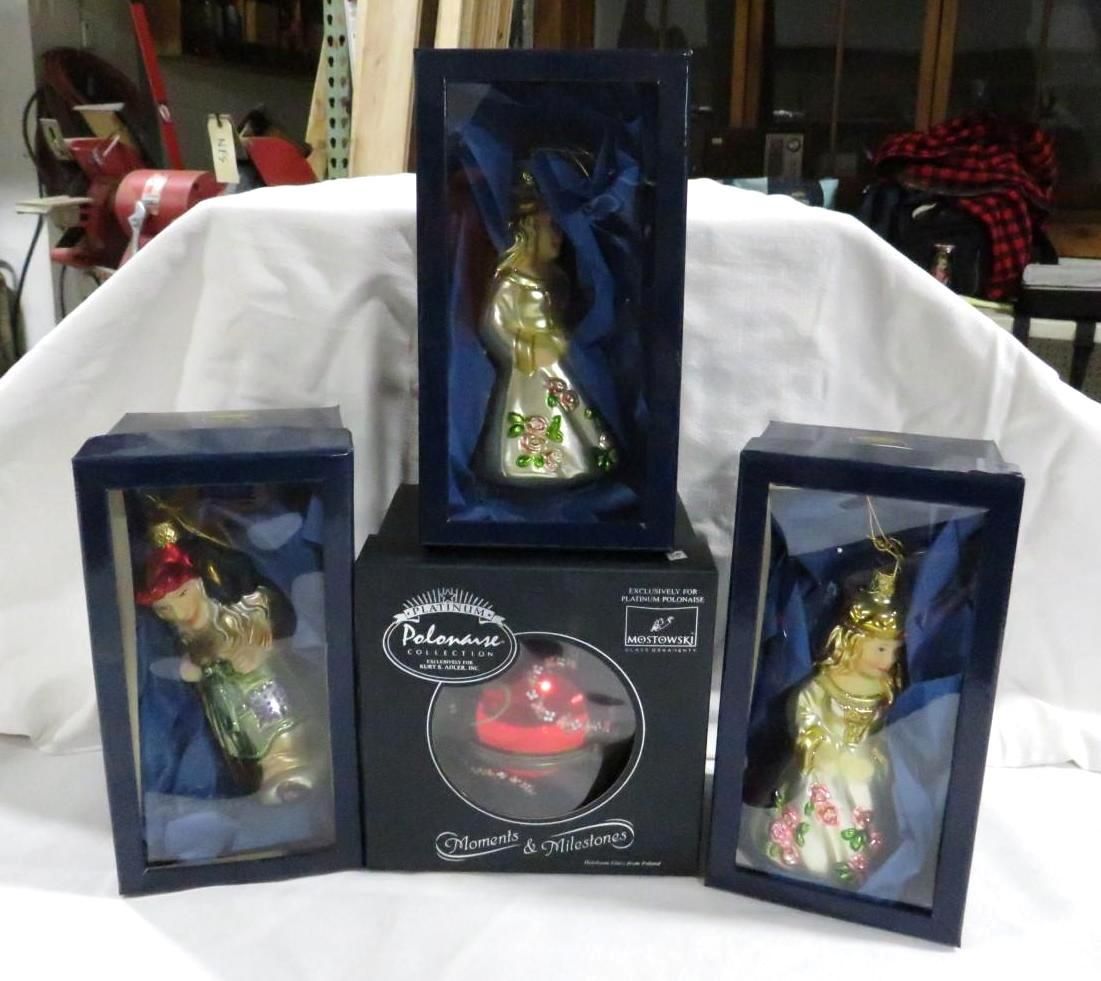 Christmas ornaments in boxes: gold figures, one red ball, blue boxes, white cloth backdrop.