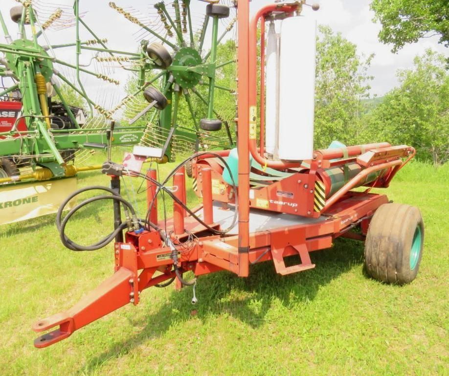 Red hay bale wrapper on a trailer.