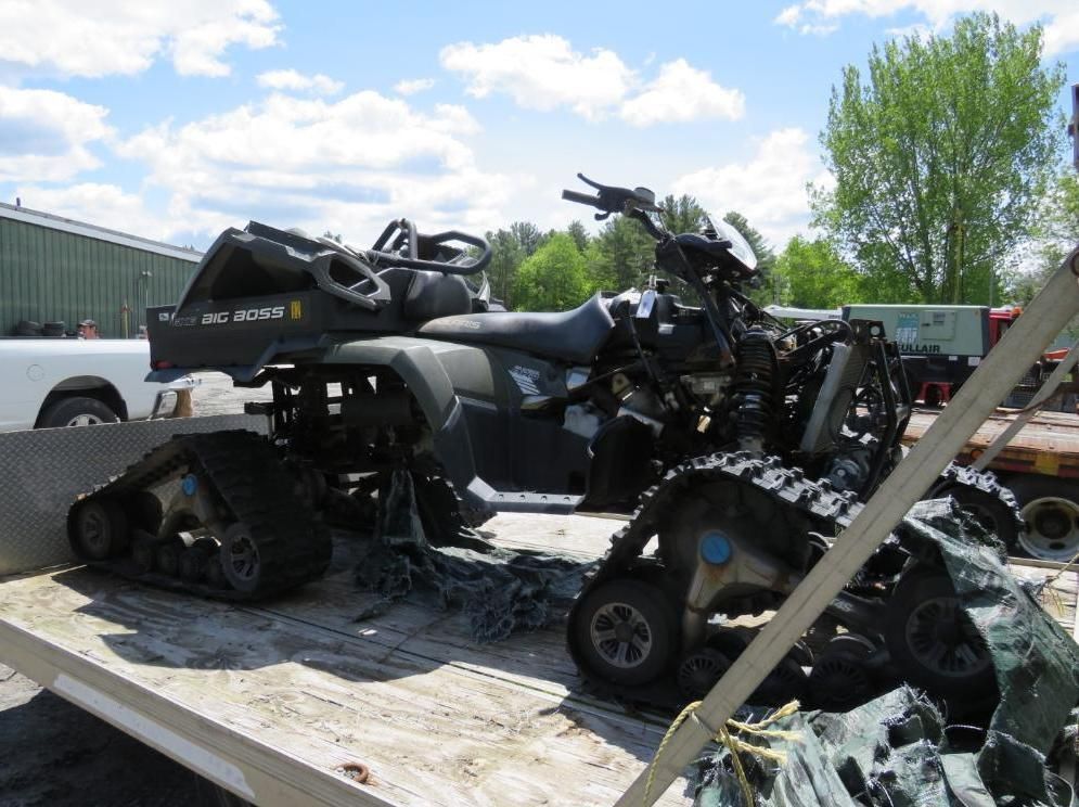 ATV with track wheels on a flatbed trailer.