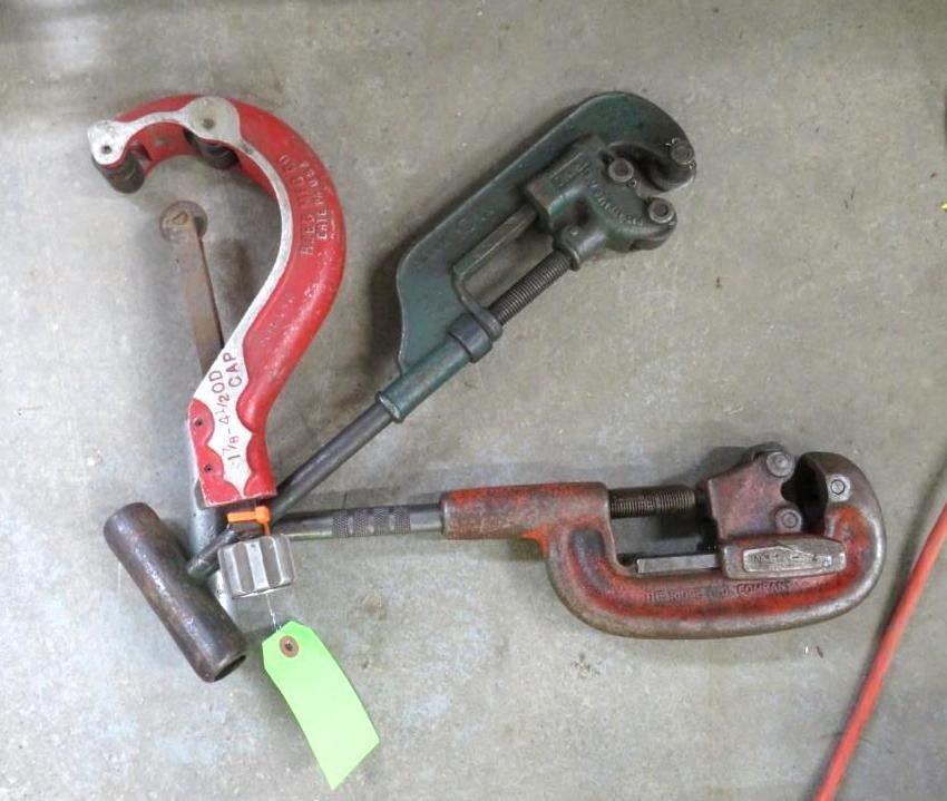 Three pipe cutters on a surface: red, green.