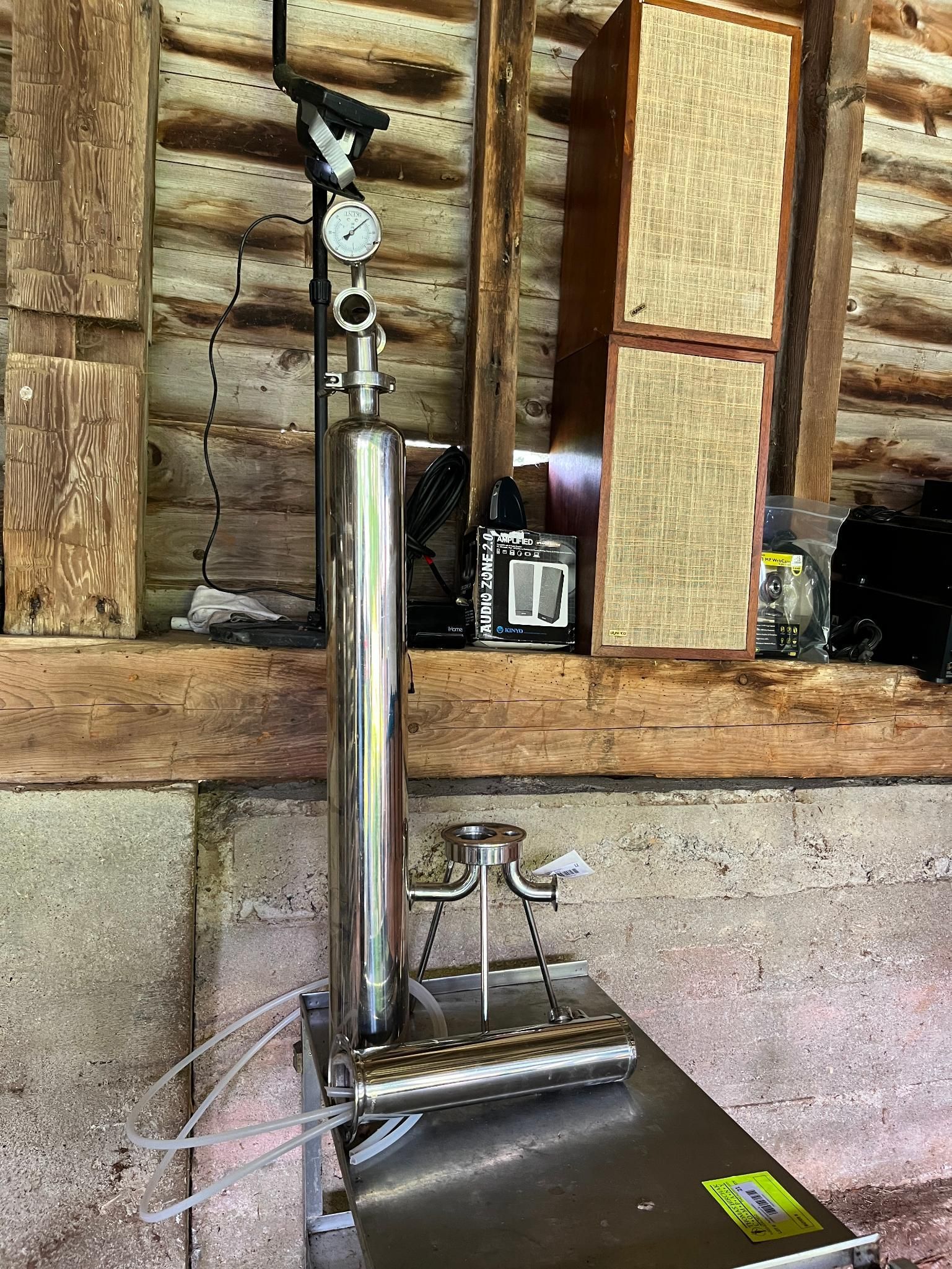 Stainless steel industrial device with gauges and valves.