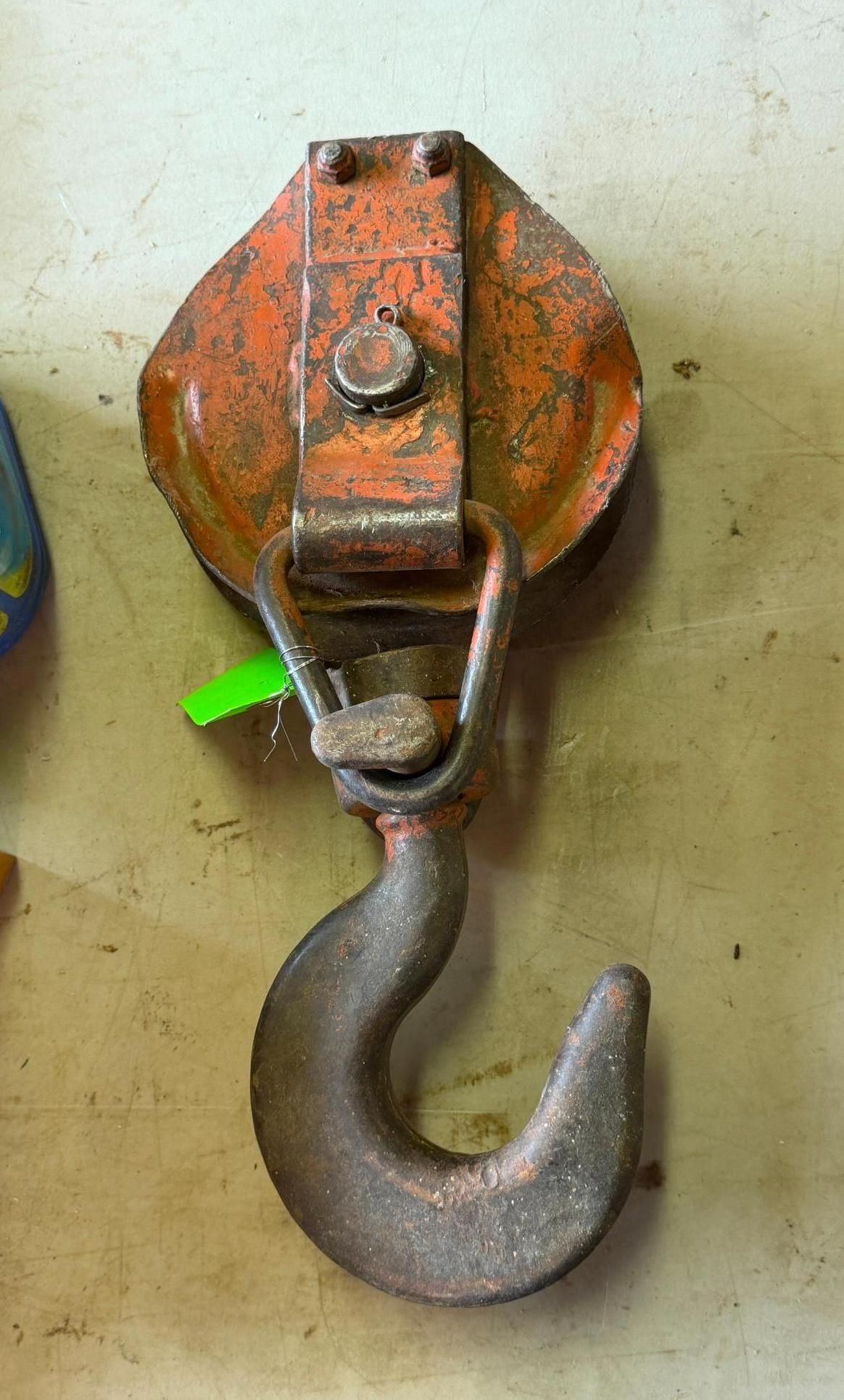 metal hook on a pulley block against a beige background