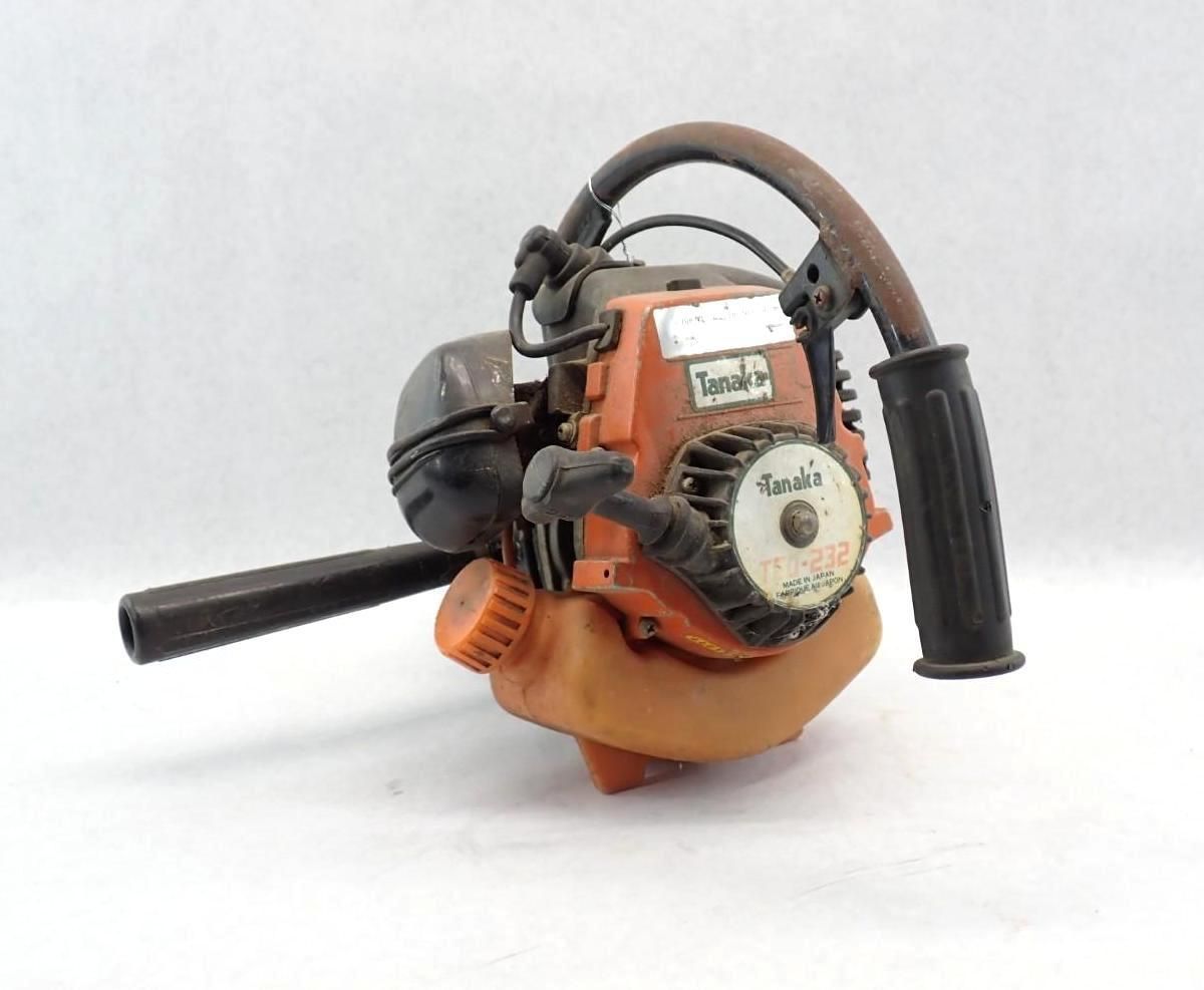 Orange and black Tanaka chainsaw on a white background. No Blade.