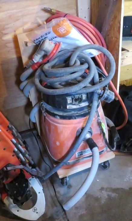 Orange shop vacuum with hoses and accessories.