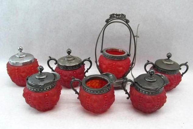 Red glass serving set with silver accents on a white background.
