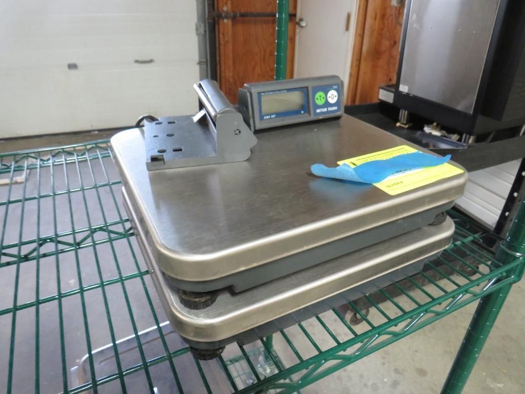 A metal scale with a digital display sits on a wire shelf.