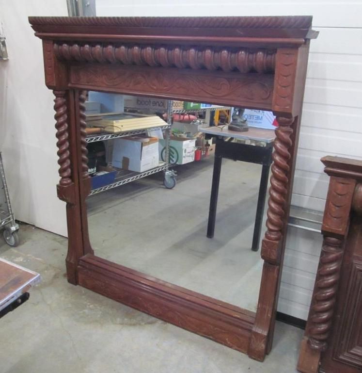 Large ornate wooden framed mirror, brown finish, with rope-like side posts and decorative top.