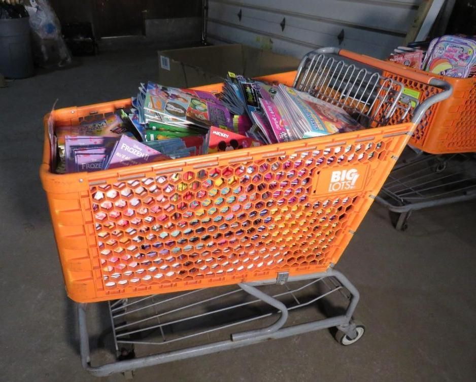 Orange shopping cart overflowing with books inside a warehouse.