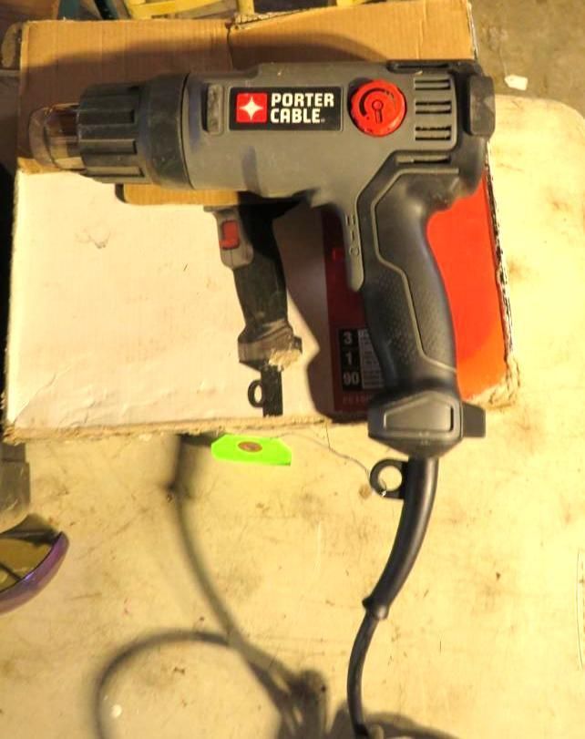 Porter-Cable heat gun on a cardboard box. Gray and red tool, black cord, indoors.