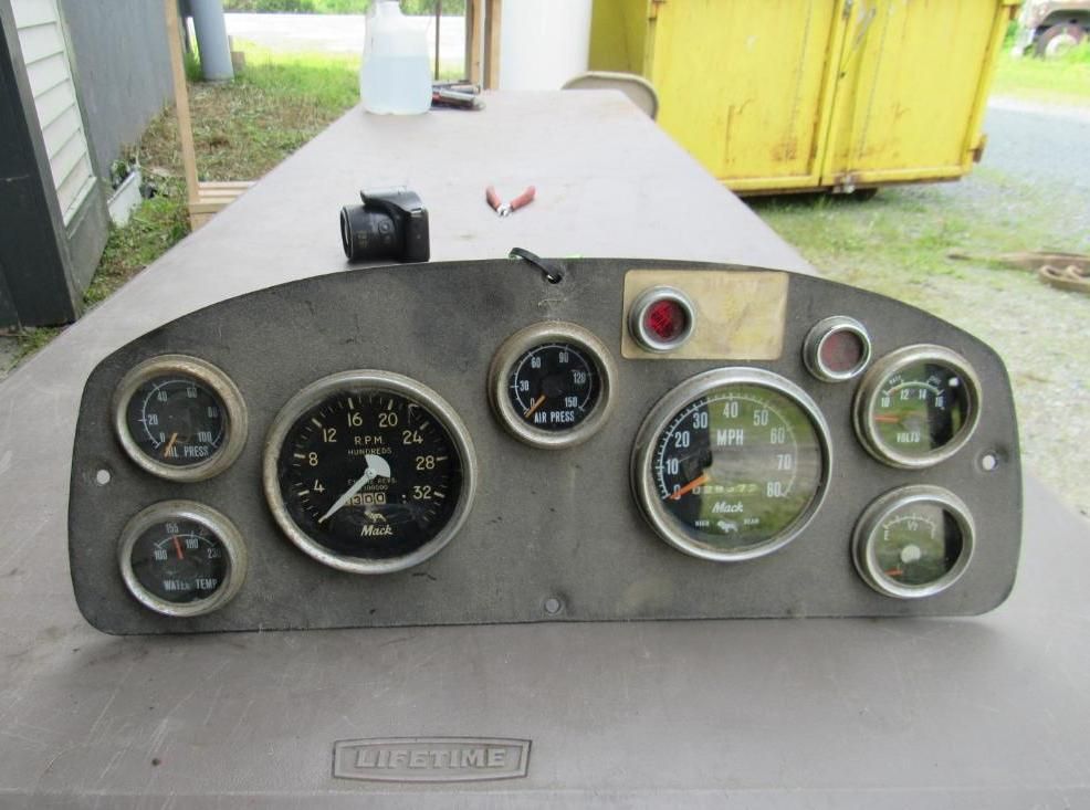 Dashboard with several gauges, speedometers, and warning lights, likely from a vehicle.