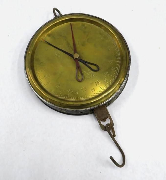 Round brass hanging scale with a hook and two hands pointing to numbers.