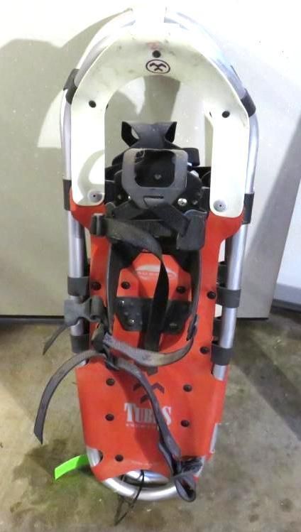 Red and white Tubs snowshoe with black straps, bindings, and a gray heel lift, viewed from above.