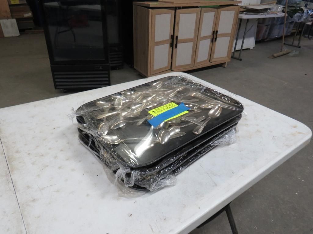 Two dark-colored, rectangular items wrapped in plastic on a white table.