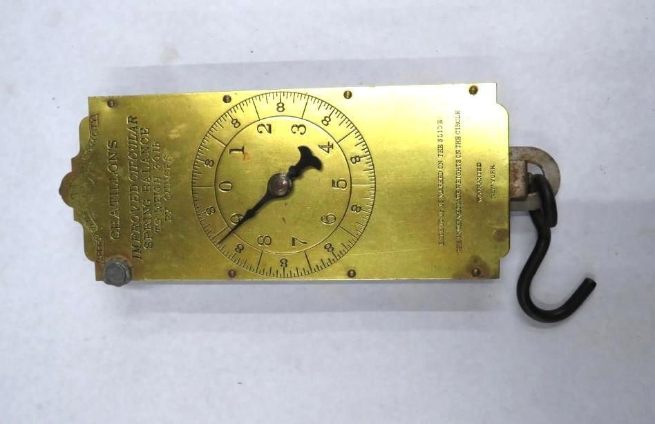 Brass scale with a black hook and a numbered dial.