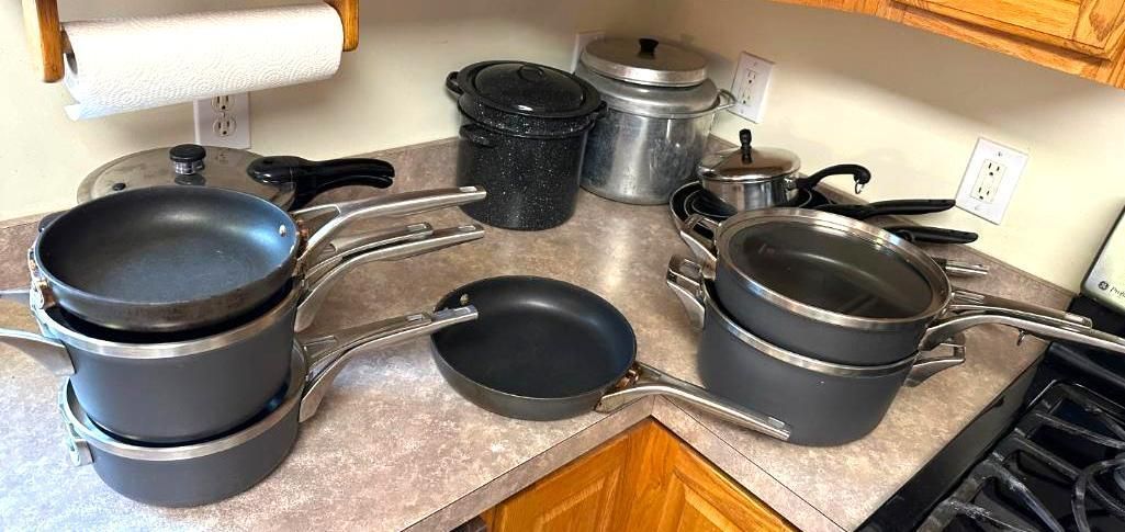 Kitchen counter with cookware: pots and pans on a metal rack.
