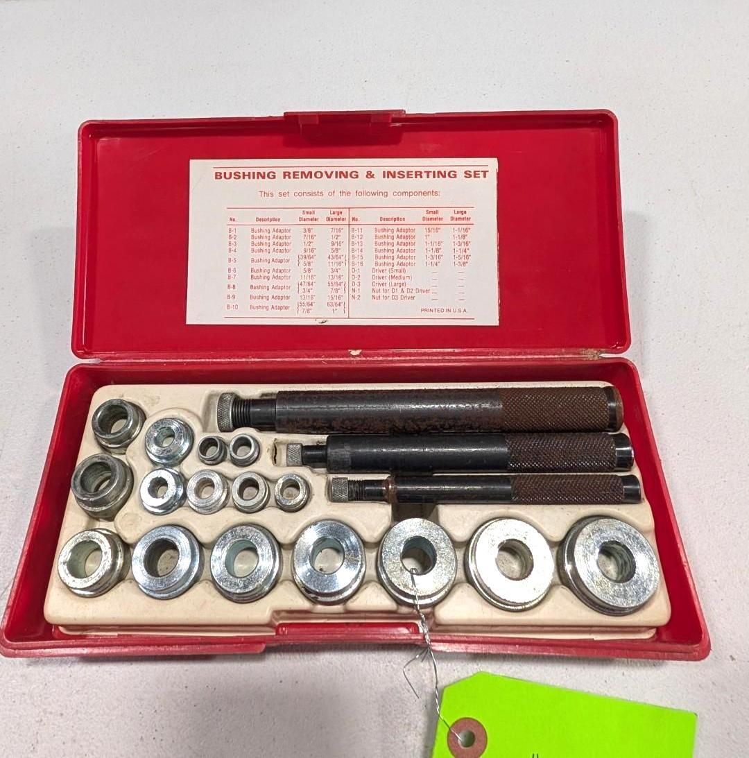 Red metal case with assorted sockets and extension bars arranged inside on a white background