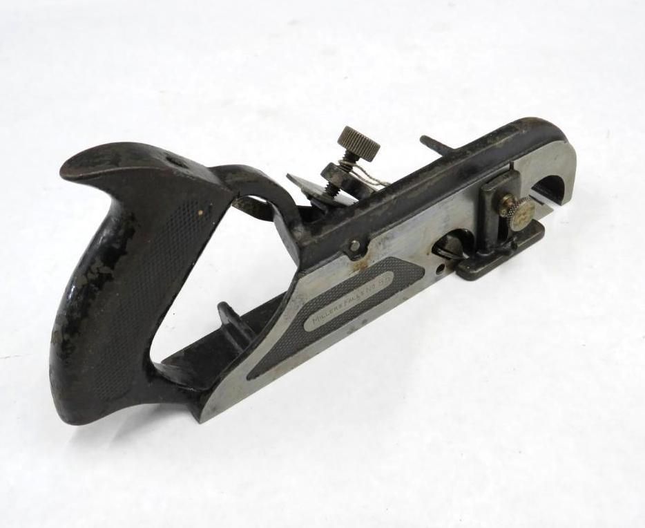 A metal woodworking rabbet plane with a black handle and adjustable blade, on a white surface.