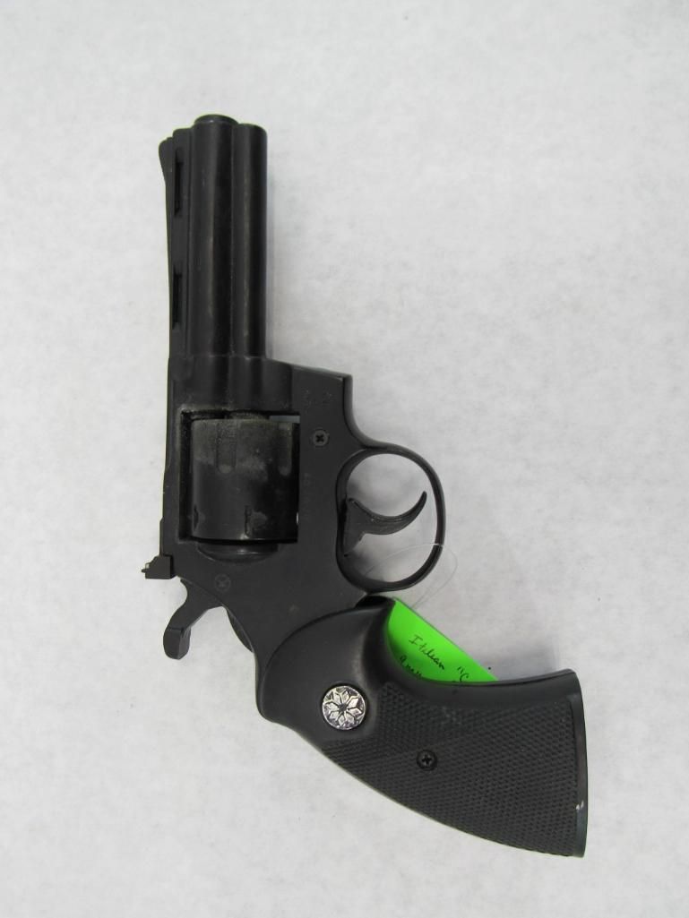 Black revolver with green accents, angled on a white surface.