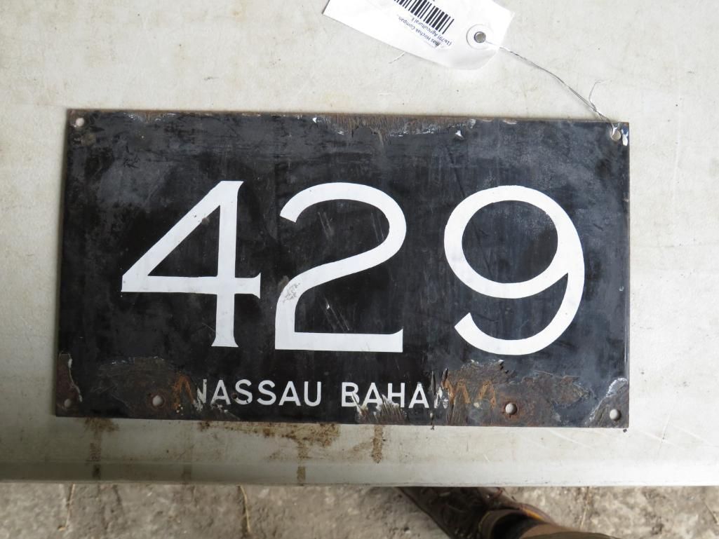 Black metal house number plate with white numbers