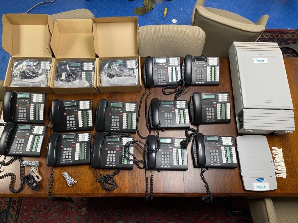 Telephones, boxes, and a server on a table; likely business equipment set up.