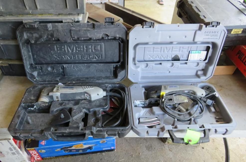 Two open tool cases with gray power tools inside. Black and gray cases with handles.
