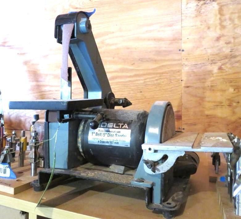 Delta belt and disc sander in a workshop setting. The machine is blue and gray.