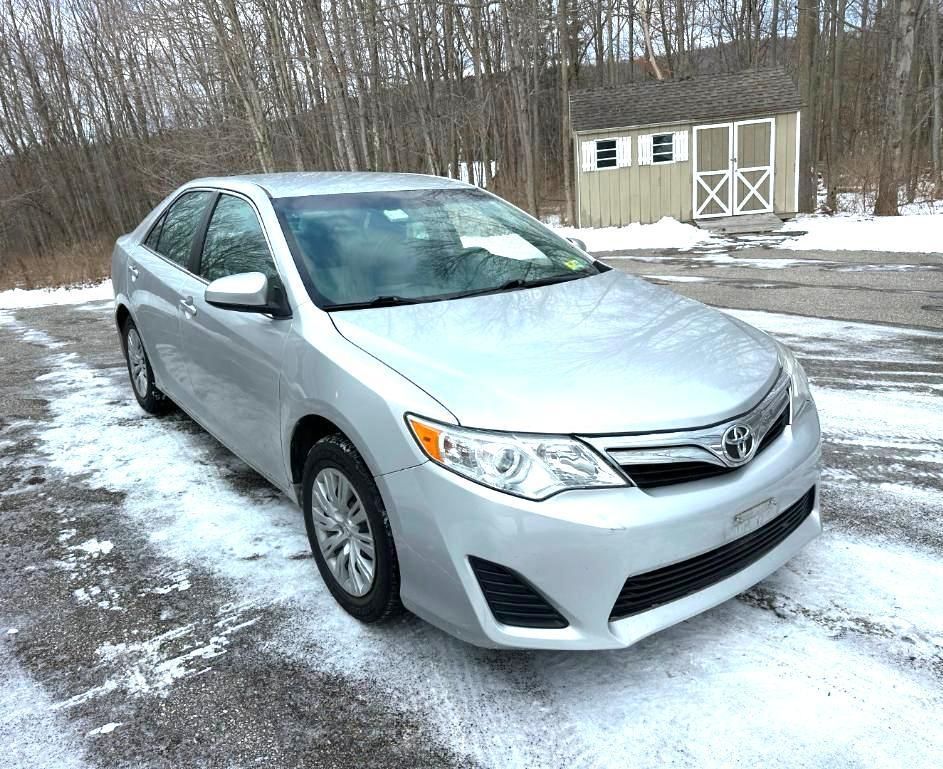 Silver Toyota Camry parked on a snow-covered surface.