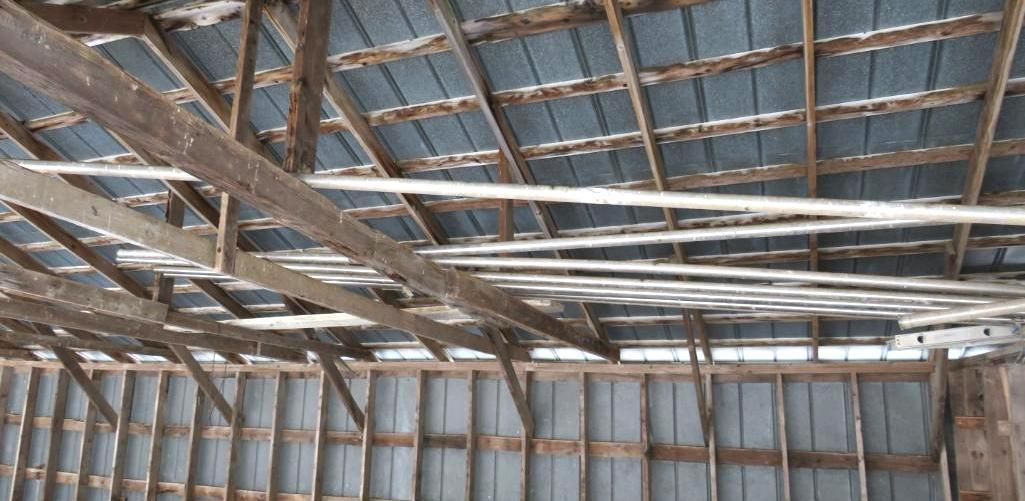 Metal piping resting in the rafters of a barn.