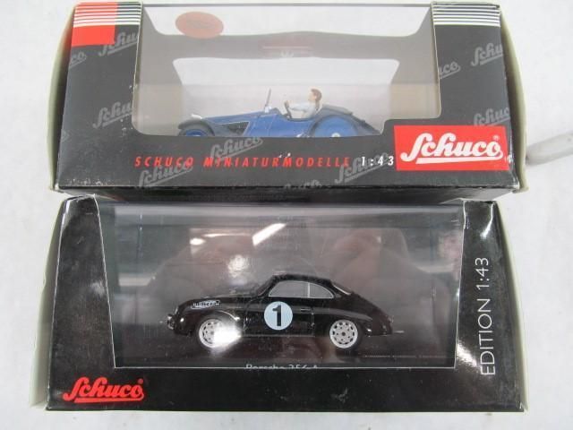 Two boxed Schuco model cars: blue open-top and black coupe, each with