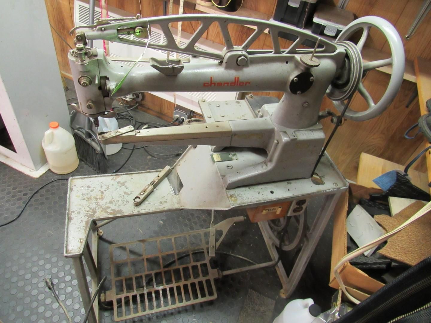 Vintage industrial sewing machine on a metal stand.