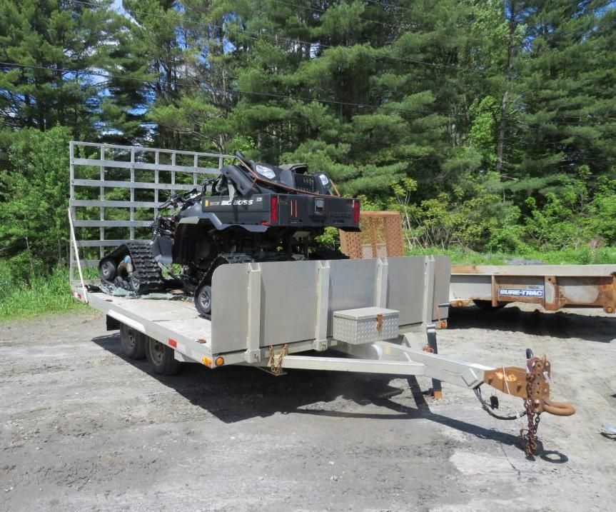 ATV with tracks on a trailer.