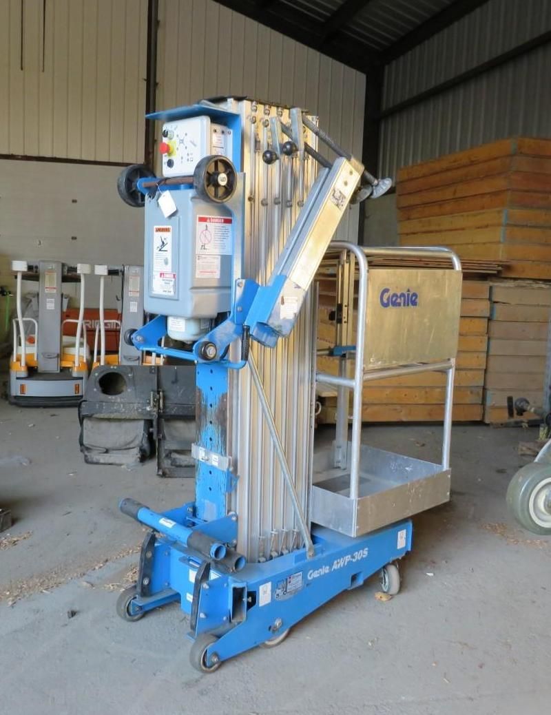 Blue and silver Genie lift in a warehouse setting.